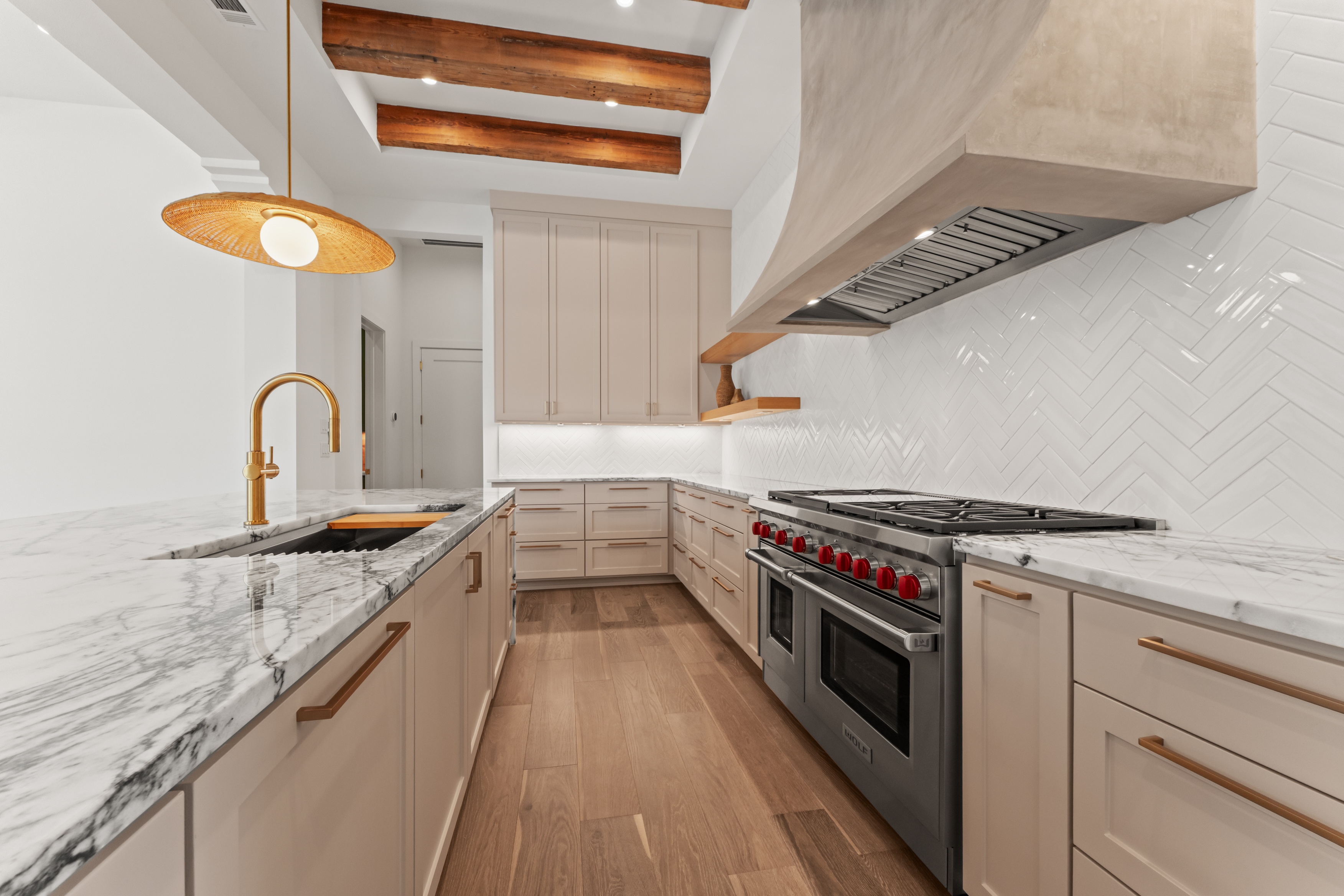 Stone surfaces, custom cabinetry, and exposed beams in the kitchen.