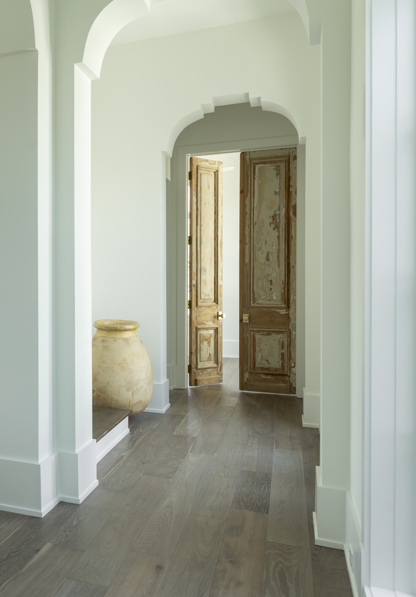 Arched hallway with antique double doors in a Burns Construction Group custom home