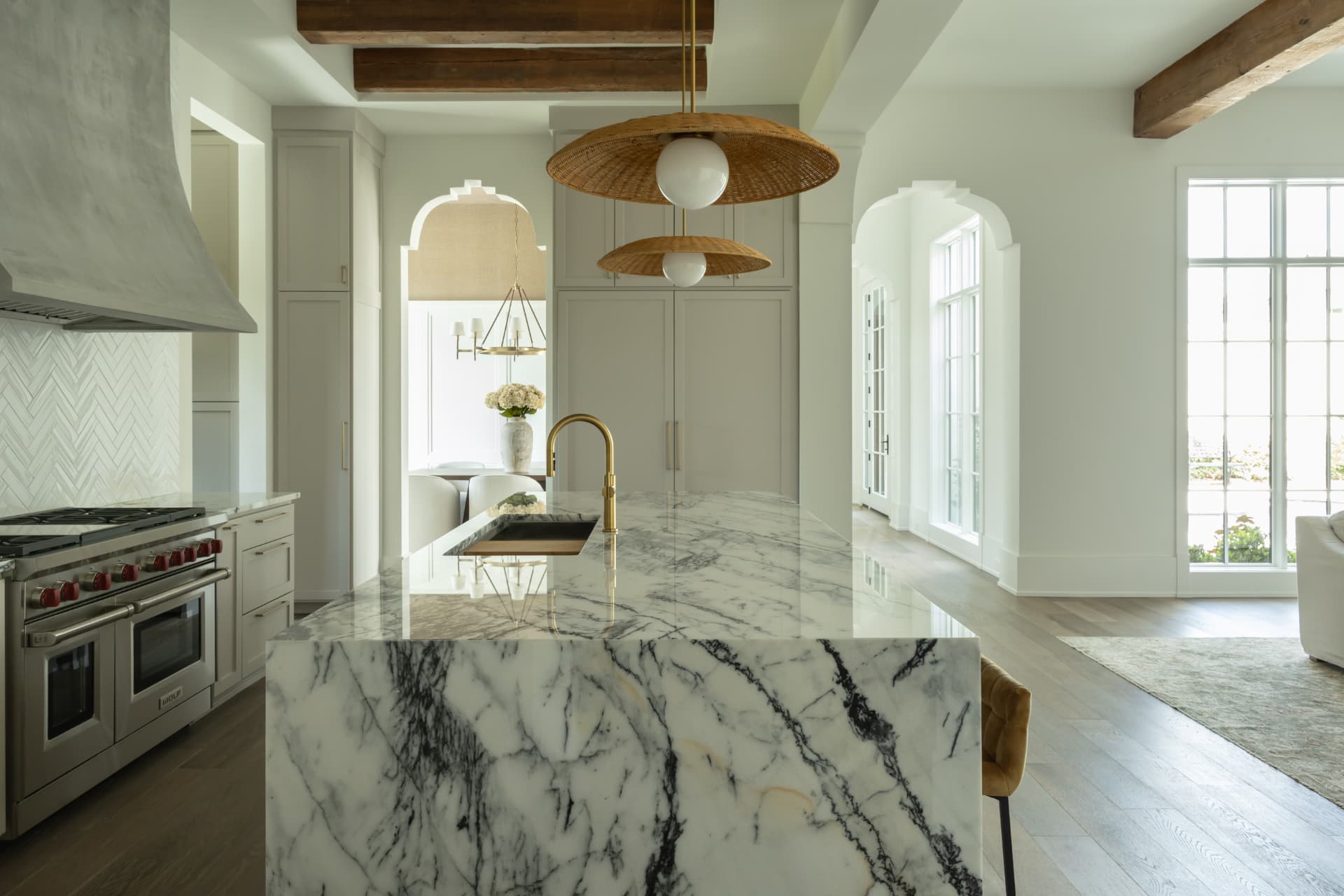 Kitchen with a marble island, reclaimed timber beams, and woven pendant lights in a BCG custom home