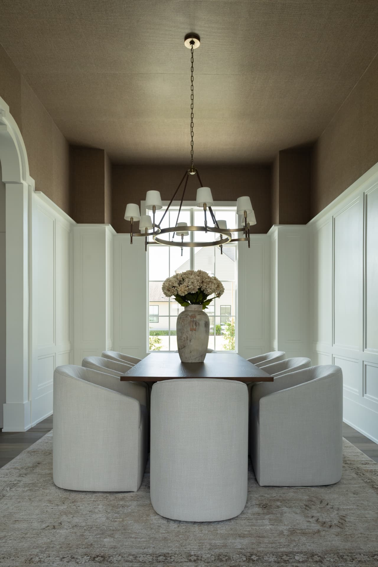 Dining room in a Burns Construction Group custom home with white panel moulding and a grasscloth ceiling