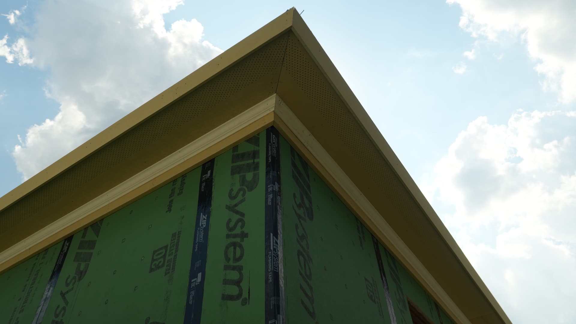 Carpenters setting soffit and fascia along the eave line.