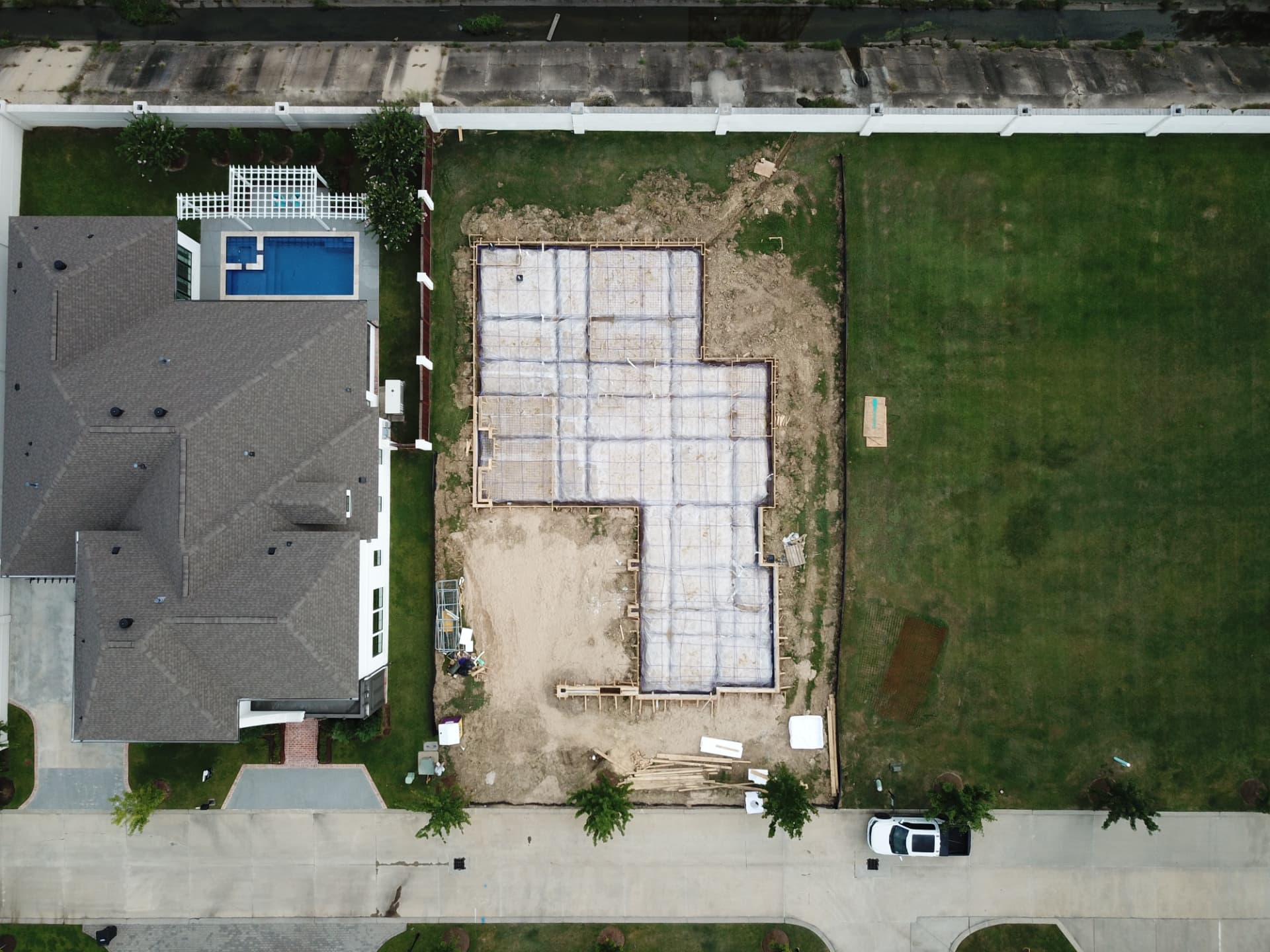 Foundation work underway beside the completed residence, viewed from above.