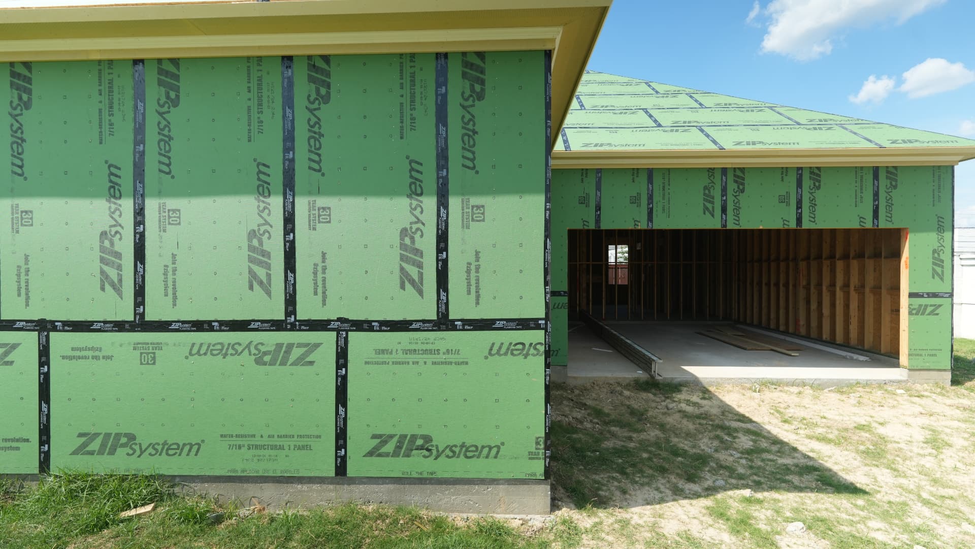 Sheathed elevations at the garage ahead of windows and cladding.